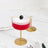 Elegant cocktail glasses with red drink and black garnish on a marble countertop.
