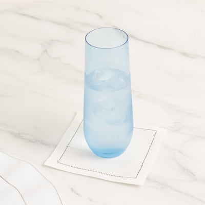 Blue glass tumbler with ice on a white napkin.