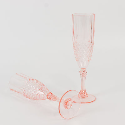 Pink crystal champagne flutes on a white backdrop