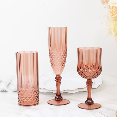 Set of three elegant pink glassware pieces on a marble table.