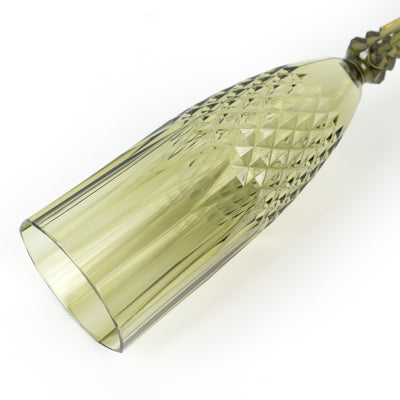Green crystal champagne flute with diamond pattern on plain white background