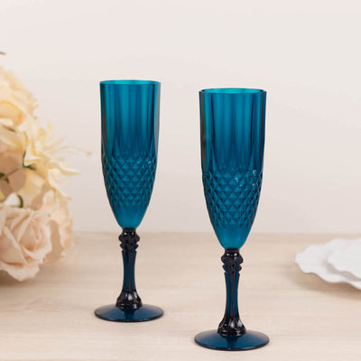 Set of two elegant blue crystal champagne flutes on a neutral background.