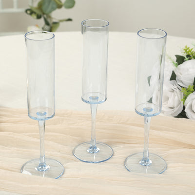 Set of three elegant blue glass vases on a table.