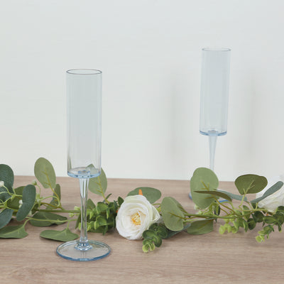 Elegant blue champagne flutes with floral accents on a wooden surface.