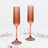 Rose gold fluted champagne flutes with long stems on white table setting