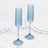 Blue ribbed champagne flutes on a white marble surface, elegant glassware set