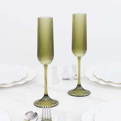 Olive green ribbed glass champagne flutes with fluted stems and pedestal bases