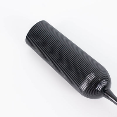 Black ribbed cylindrical hand tool on white background