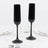 Black ribbed champagne flutes with fluted stems on a white table setting