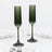 Green ribbed glass champagne flutes with fluted stems on a white marble table
