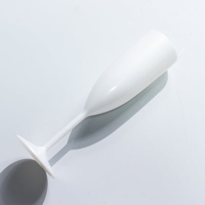 White champagne flute on a plain background.