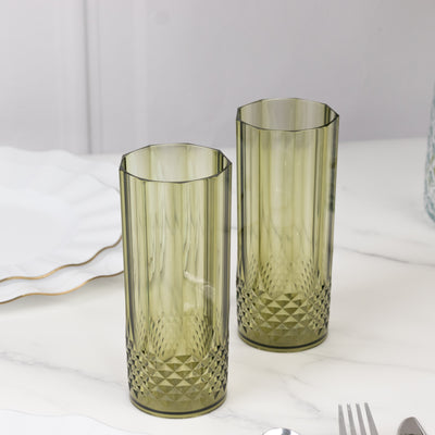 Green textured drinking glasses on a marble surface.