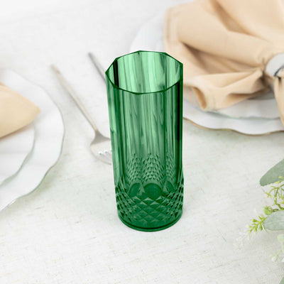 Green textured glass vase on a table with neutral linens.