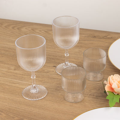 Set of clear ribbed glassware on wooden table.