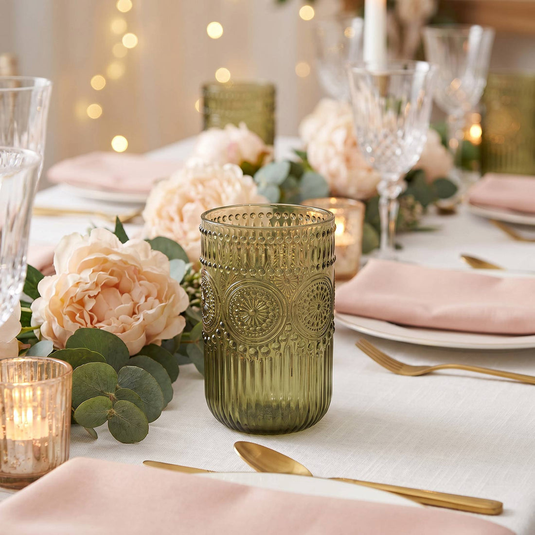 Elegant blush and gold tablescape with floral centerpiece and green glass votive candle holder