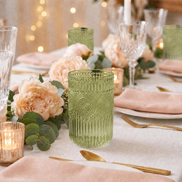 Elegant floral tablescape with green textured glassware, blush napkins, and gold flatware