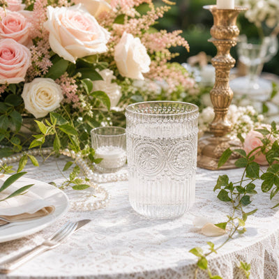 Elegant floral table setting with roses, crystal glassware, and gold candlestick