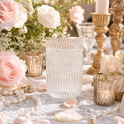 Elegant floral table setting with glass candle holders and pink roses