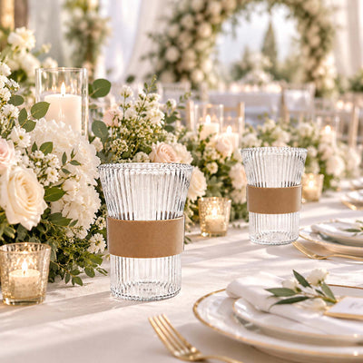 Elegant wedding table centerpiece with candles, white flowers, and glassware