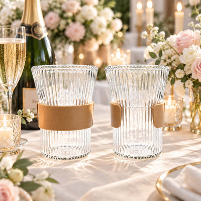 Elegant ribbed crystal drinking glasses with leather bands on a romantic table setting