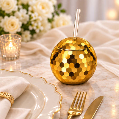 Gold disco ball cup with clear straw on an elegant dining table setting