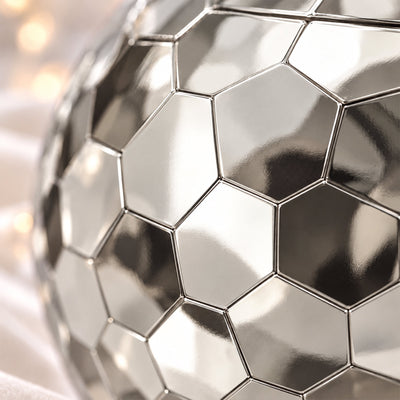 Close-up of silver disco ball cup lid and clear straw with faceted hexagon tiles