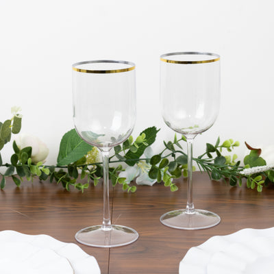Elegant clear wine glasses with gold rim on a wooden table