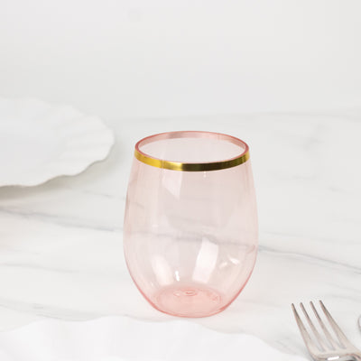 Pink glass tumbler with gold rim on a marble surface