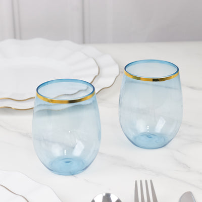 Two elegant blue glasses with gold rims on a marble table.