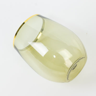 Gold-trimmed green glass tumbler in a studio-style isolation shot