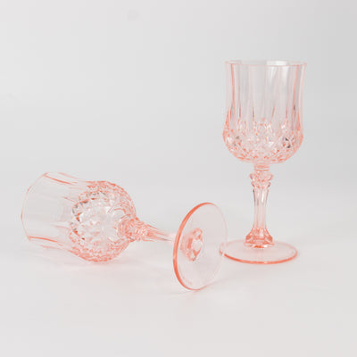 Pink crystal wine glasses on a white background