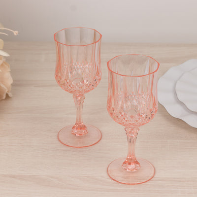 Set of two elegant pink crystal goblets on a wooden surface.