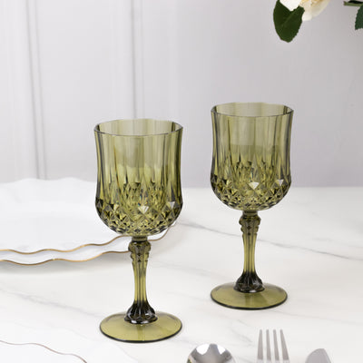 Green crystal goblets on a marble surface with elegant tableware.