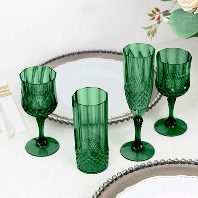 Set of four elegant green crystal glasses on a table setting.
