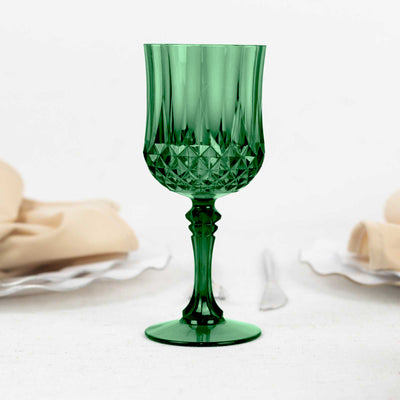 Green crystal goblet on a table setting with napkins and cutlery.