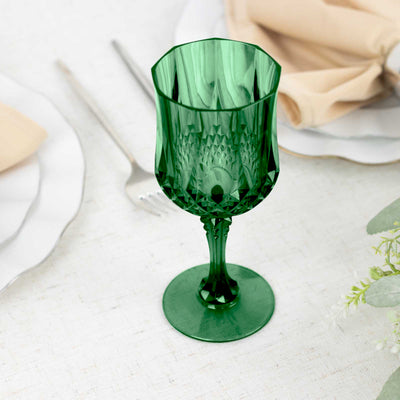 Green decorative glass goblet on a textured table setting.