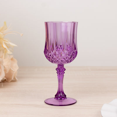 Purple crystal goblet with intricate cut design on a plain background.
