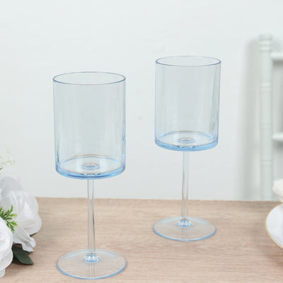 Two elegant blue stemmed glasses on a neutral table setting.