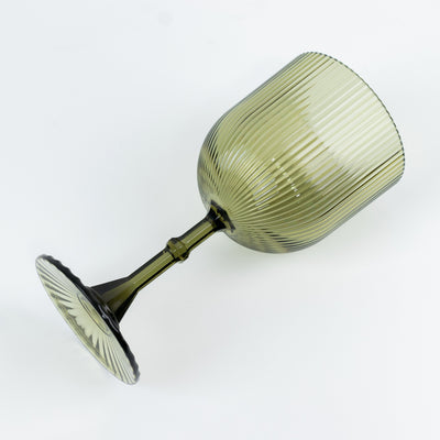 Green ribbed glass goblet on a white background