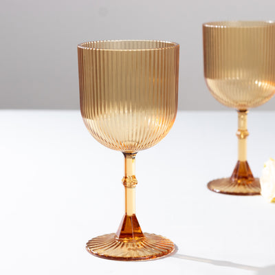 Amber ribbed glass goblet on a white background.
