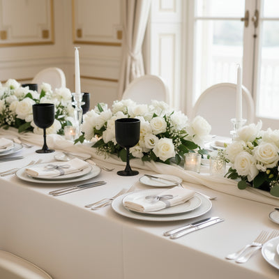 Elegant dining table setting with white roses and candles.
