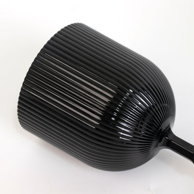 Black ribbed ceramic cup with a sleek design.