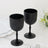 Black ribbed stemmed glasses on a marble surface with decorative plates