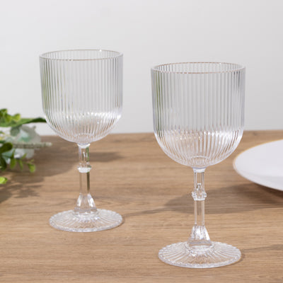 Elegant ribbed crystal wine glasses on a wooden table.