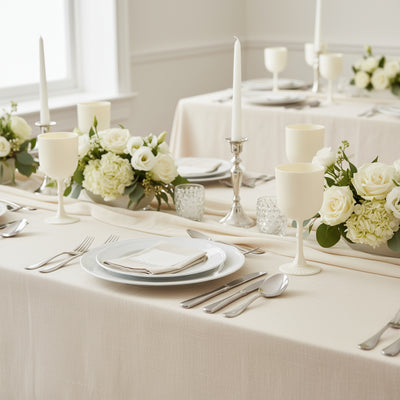 Elegant dining table set with candles and floral arrangements.