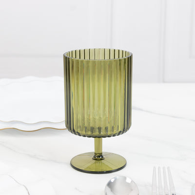 Green ribbed glass tumbler on a marble table.