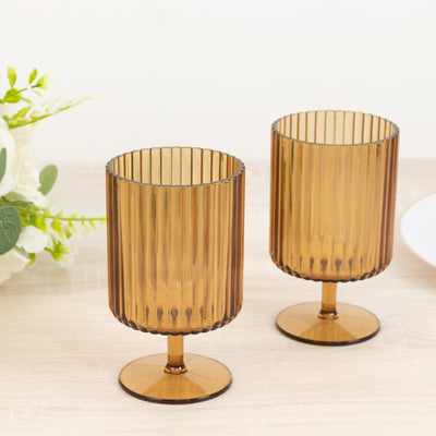 Amber ribbed glassware set of two on a wooden table.