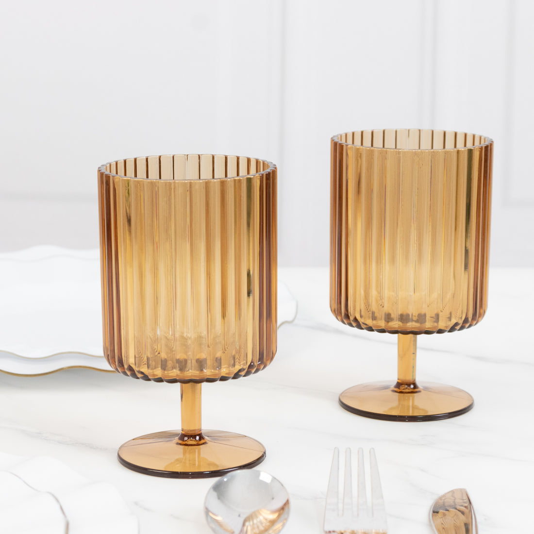 Amber ribbed glass cups on a marble surface.