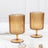 Amber ribbed glass cups on a marble surface.