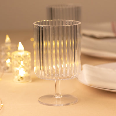 Clear ribbed glass candle holder with a pedestal base.